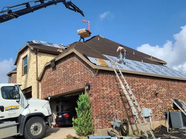 Boom truck delivering shingles to the roof